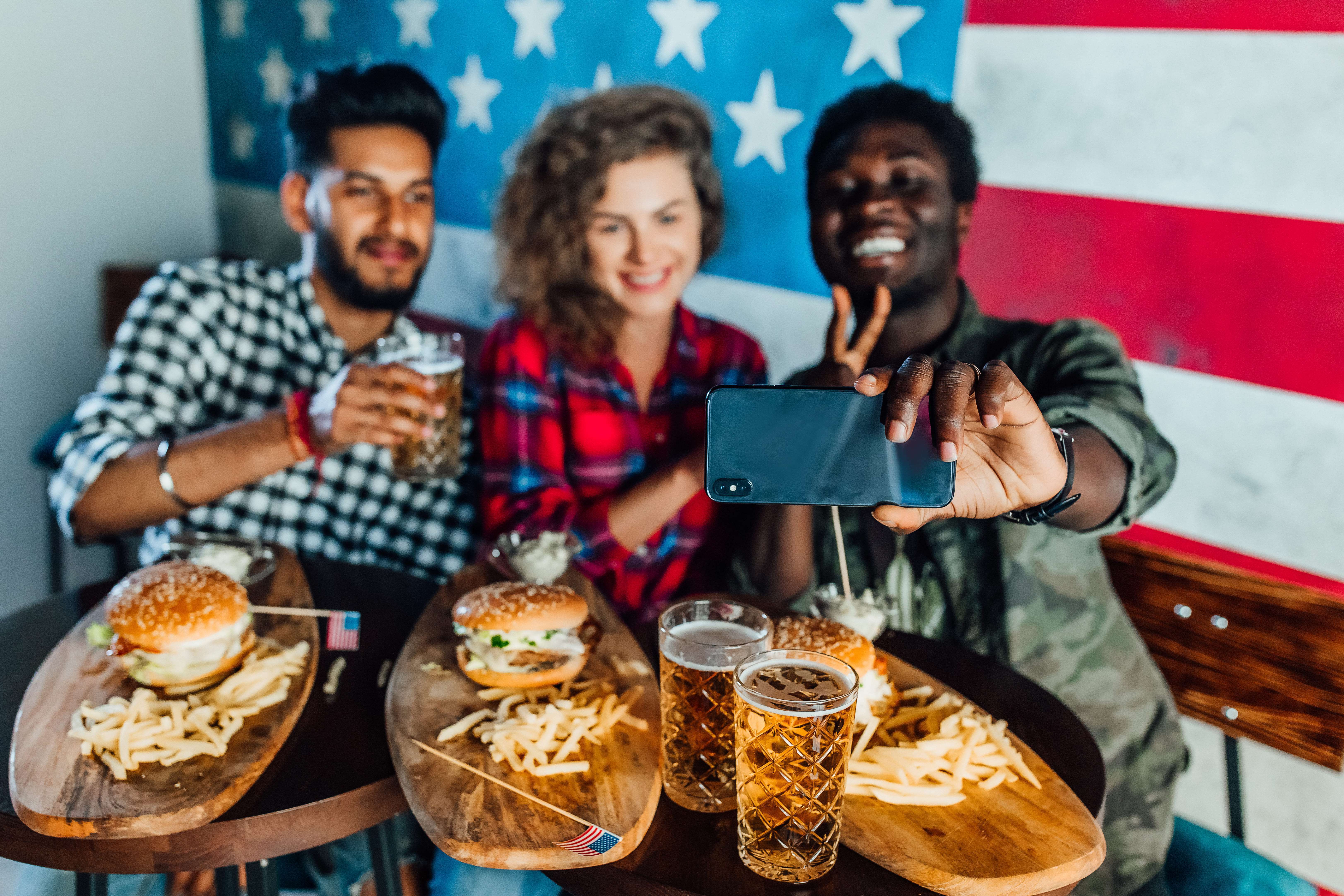 happy-three-friends-fast-food-restaurant-taking-selfie-while-they-are-eating-burgers-drinking-beer (1).jpg